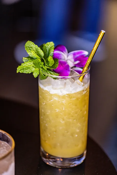 A tiki cocktail with orchid garnish